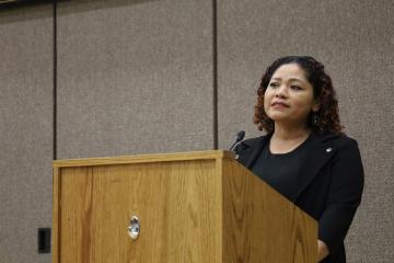 A woman at FLTI graduation speaks at a podium.