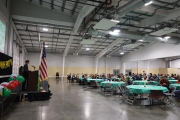 A 4-H member stands on the stage a achievement night in front of a large crowd.