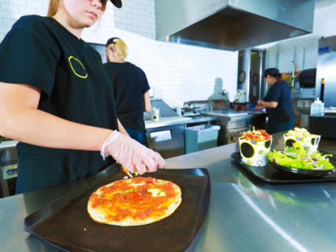 Three employees prepare food in a resaturant