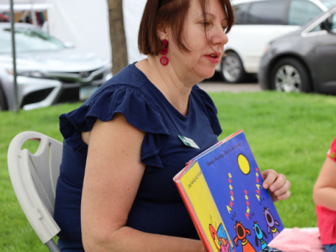 Larimer County Commissioner Kristin Stephens reading a children's book at the Larimer County Farmers' Market